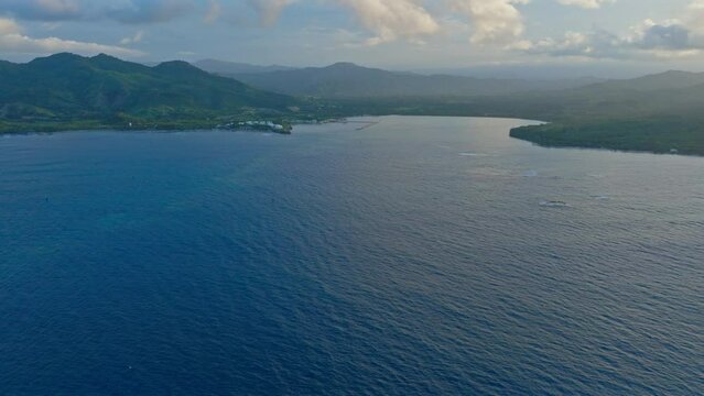 Calm and blue waters of Maimon Bay at dusk, Puerto Plata in Dominican Republic. Aerial forward