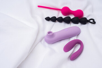 Various sex toys on the white bedding