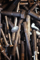 Old rusty bolts and screws lie in a pile