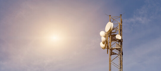 Bad radiation, directional antenna in front of blue, slightly cloudy sky with strong sunlight.