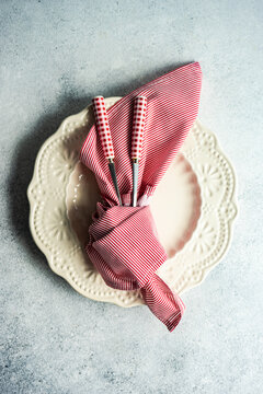 Overhead view of a festive place setting with a red napkin tied around cutlery