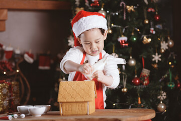 young girl making gingerbread house at home