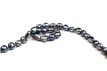 Baroque pearls strand. Natural freshwater black pearl beads on white background. Side view
