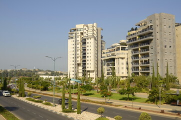 Fototapeta na wymiar Beautiful residential building. Modern housing. Israel - high-rise building, flowering and palm trees. Concept: nice place to live, real estate purchase 