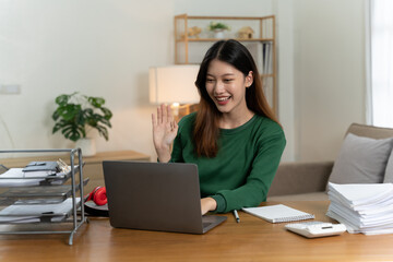 Asian girl with laptop computer on desk.