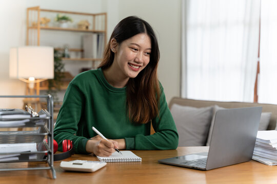 Asian girl with laptop computer on desk.