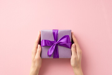 New Year concept. First person top view photo of woman's hands giving lilac giftbox with purple...