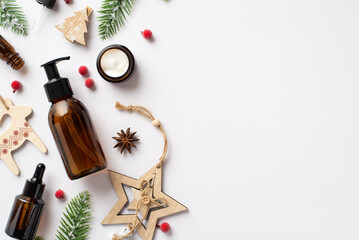 Winter skincare products concept. Top view photo of amber glass bottles cream jar christmas wooden...