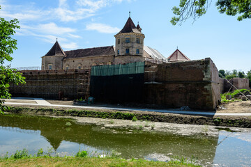 Renovated old historical buildings  of Fagaras Fortress (Cetatea Fagaras) during renovation works in a sunny summer day, in Transylvania (Transilvania) region, Romania  .