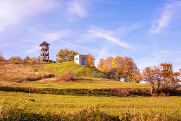 Fototapeta premium Watchtower on the green meadow on a sunny day.Autumn landscape.