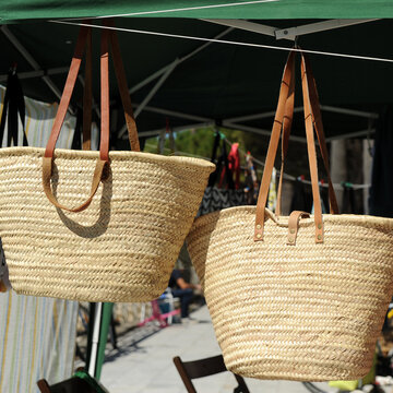 Handmade wicker beach baskets for sale at an outdoor craft market. Wicker handicrafts