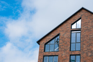 A beautiful brick building with large windows, on the background of the blue sky