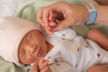 lifestyle shot of woman hands handling adorable newborn baby girl at hospital immediately after birth in new life and parenting concept