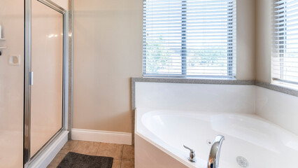 Panorama Bathroom interior with corner bathtub and shower stall with glass and aluminum frame
