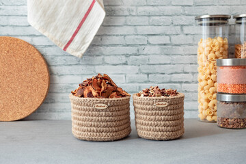 zero waste plastic-free kitchen, eco-friendly food storage, dried fruits and nuts in jute baskets, cereals and pasta in glass jars