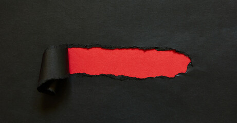 red ripped hole in black paper