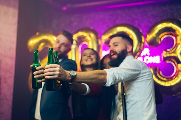 Focus on a alcohol bottles while people toasting and celebrating in the club