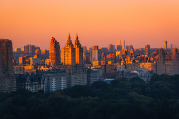 Fototapeta premium Aerial view of the Central park in Manhattan, New York with golf fields and tall skyscrapers surrounding the park. Sunset view.