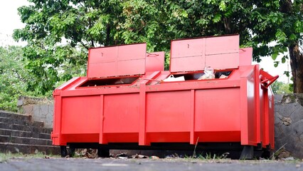 Metal durable orange industrial trash bin for outdoor trash at construction site. Large waste...