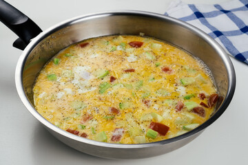 Omelette stuffed with vegetables in pan on the table.