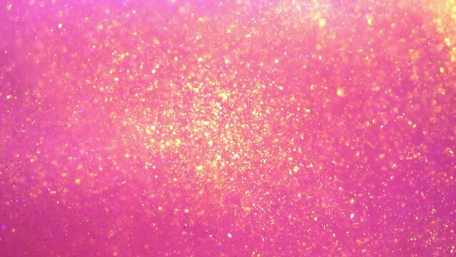 Abstract waves of moving gold particles on a pink background. Beautiful Gold glitter glitter smooth motion. A fluid stream of gold dust particles moving chaotically and flowing in pink liquid. 