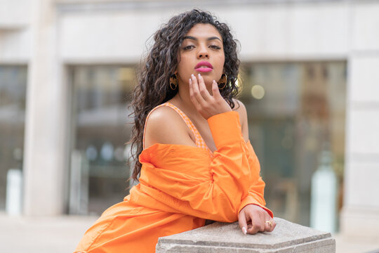 posed of a pretty brunette woman, with curly hair. fashionably dressed