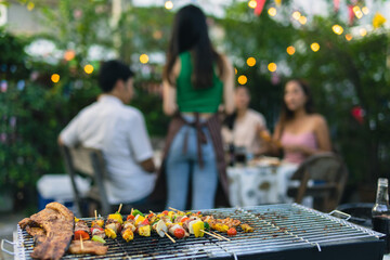 Cute Asian woman grilling for a group of friends.