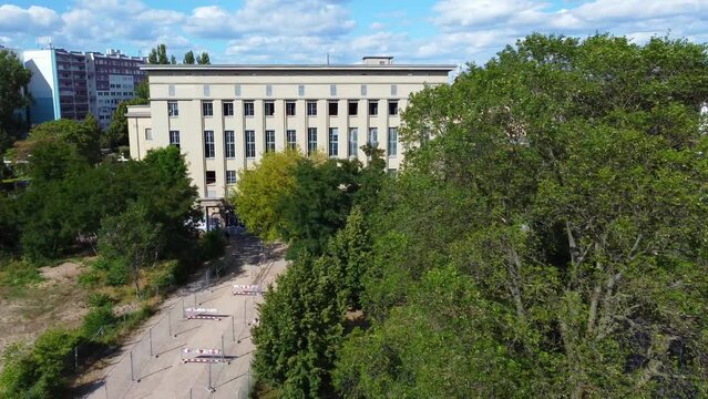 Famous techno club disappears behind a tree. Stunning aerial view flight berlin