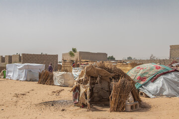 Fototapeta premium Refugee camp in Africa, full of people who took refuge due to insecurity and armed conflict. People living in very poor conditions, lack of food, clean water and proper shelter to stay in