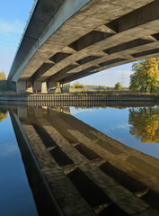 Concrete bridge over a river and reflection