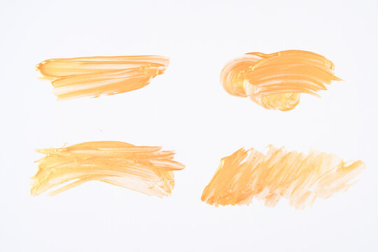 Set Of Gold Brushstrokes Of Acrylic Paint On White Background