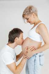 husband kissing belly of pregnant wife