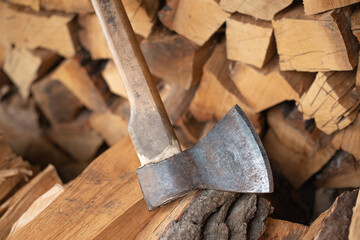 Axe on the background of stacked firewood