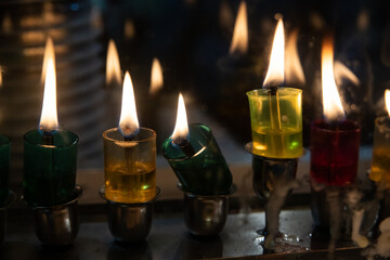 Obraz na płótnie Canvas Multi-colored glass vials hold oil and wicks to light the Hanukkah menorah during the celebration of the Festival of Lights in Israel.