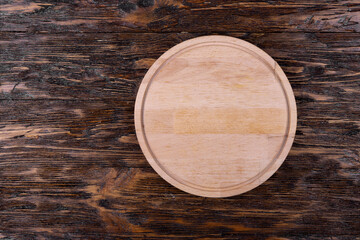 Empty kitchen board on a wooden background. Cutting board. Space for text.