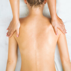 massage of the back and collar zone, hands of the massage therapist massage the neck and back, top view,