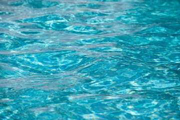 Background of blue water in swimming pool with sun reflection, ripple water wave in pool. Clear water background.