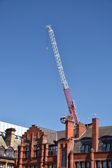 Modern buildings under construction with large cranes and machinery. 