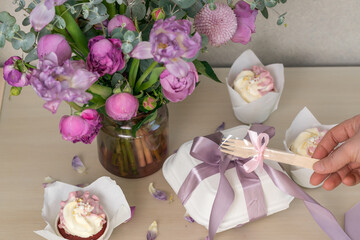 Cake packaging. The girl ties the ribbon to the packing box.
