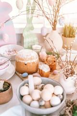 happy easter and spring holidays time. festive tablescape set decor. traditional dinner food easter eggs and baked cakes on table at home. rabbit and willow. pale pop pastel blue and pink color. flare