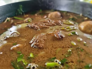 Braised meat noodles in a ceramic cup, Place on the table ready to serve.There was a thin smoke coming from the noodle cup. close-up macro shot.