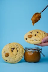 Fotobehang Chocolate cookies and peanut butter jar © Nina Ljusic/Wirestock Creators