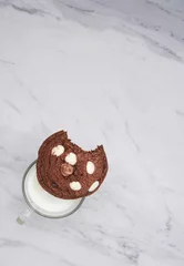 Fotobehang Chocolate cookie and a cup of milk for breakfast © Nina Ljusic/Wirestock Creators