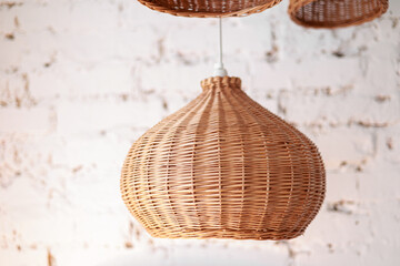 three rattan chandeliers different forms on white brick wall background. Straw lampshade in cozy living room. Eco-friendly interior design using natural materials. Scandinavian interior. copy space