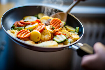 cooking tasty vegetable mix in pan on kitchen