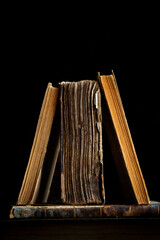 Trois vieux livres sur un fond noir