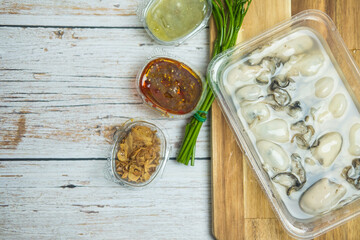 Selective focus raw fresh oysters in box served with on sidedish.