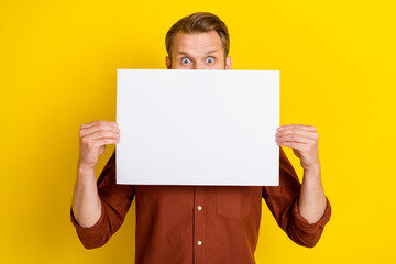 Photo of interesting boy man dressed stylish brown clothes arm hold paper sheet cover face empty space isolated on yellow color background