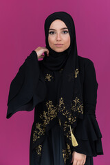 beautiful muslim woman in fashinable dress with hijab isolated on modern pink background representing concept of modern islam and ramadan kareem