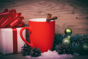 Christmas Cup and the Christmas gift on wooden background